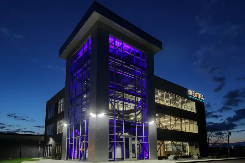 Nighttime exterior photo of three story corporate office construction.
